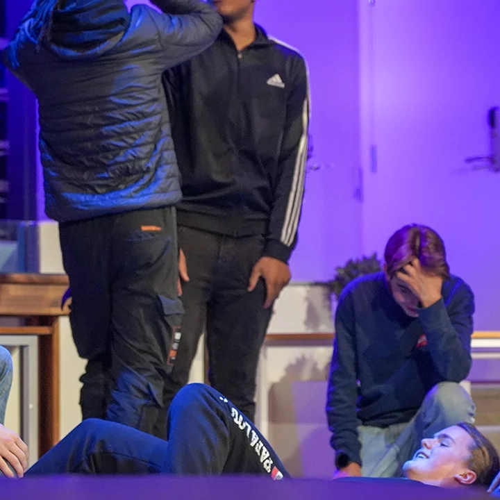 Unge mennesker ler sammen i aulaen